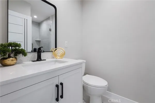 a bathroom with a sink a toilet and mirror