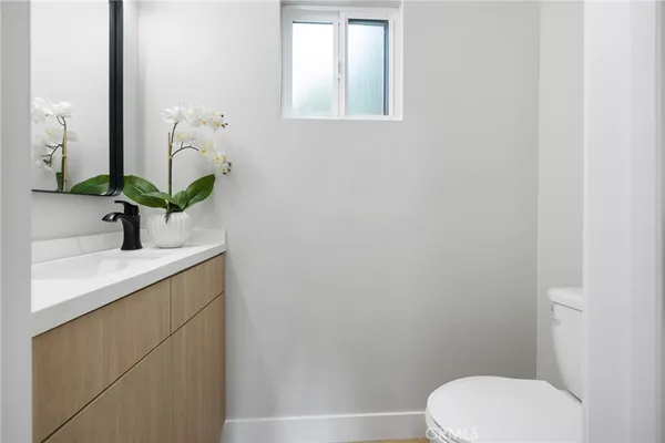 a bathroom with a sink a toilet and mirror