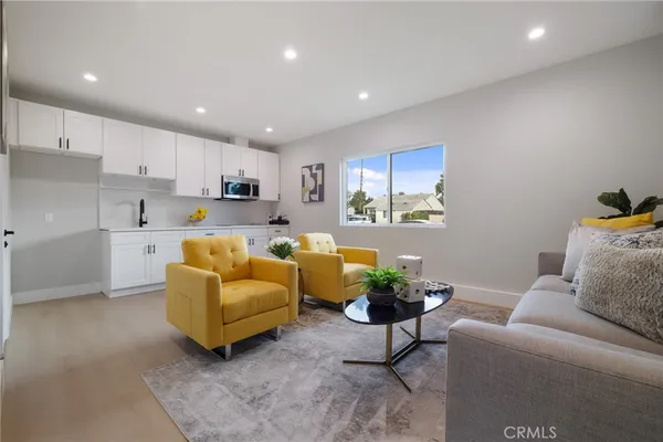 a living room with furniture and a kitchen view