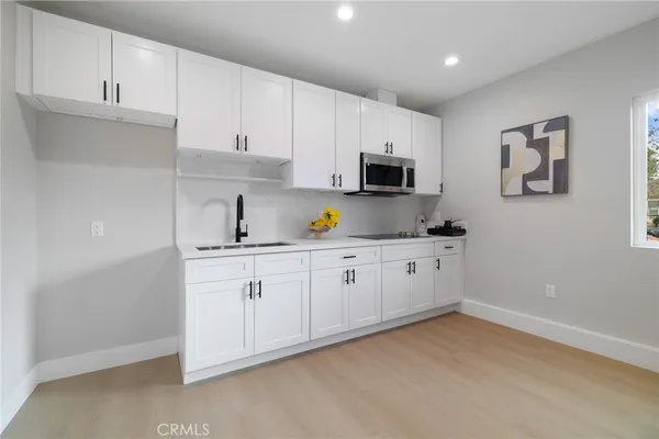 a kitchen with appliances a sink and cabinets