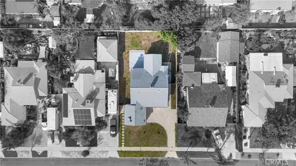 an aerial view of residential houses with outdoor space and parking