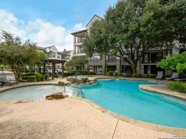 a view of a swimming pool and lounge chairs in the patio