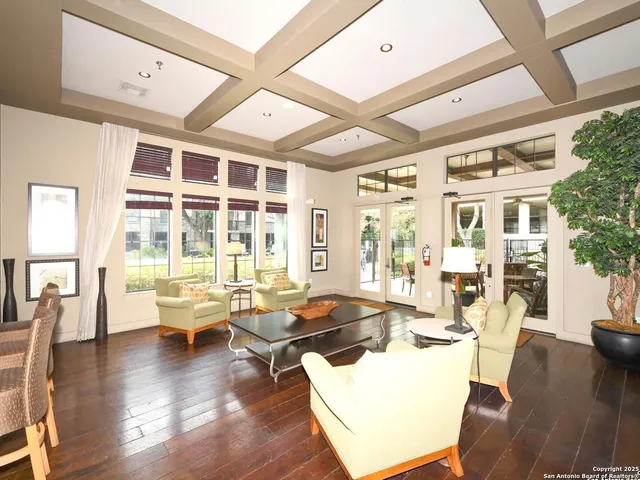 a living room with furniture large wooden floor and large windows