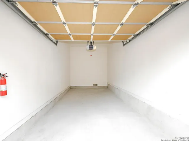 a view of a white house with a large windows next to a road