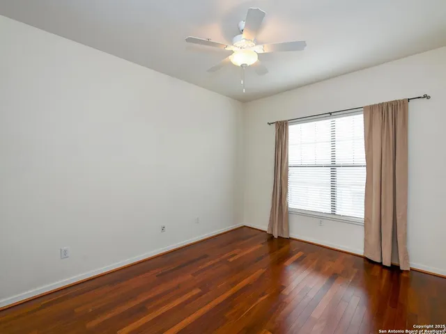 an empty room with wooden floor and window