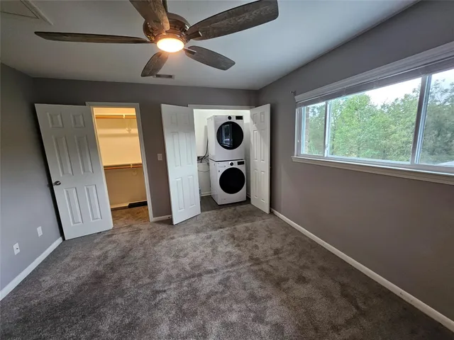 a view of an empty room with a window and closet