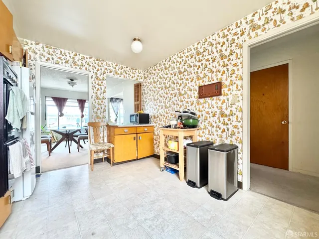 a view of a kitchen with a sink and dishwasher with white walls