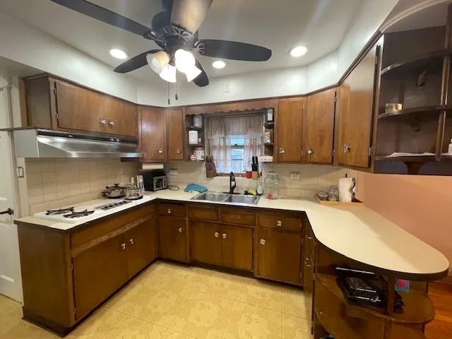 a kitchen with stainless steel appliances granite countertop a sink a stove and a refrigerator