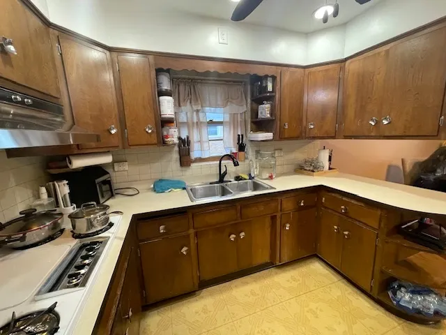 a kitchen with a sink a stove and cabinets