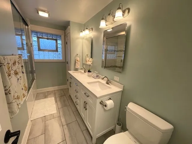 a bathroom with a sink mirror and toilet