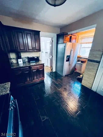 a kitchen with granite countertop wooden cabinets and a stove top oven