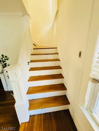 a view of a hallway view with wooden floor and staircase