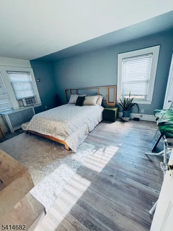 a bedroom with a bed potted plant with the wooden floor