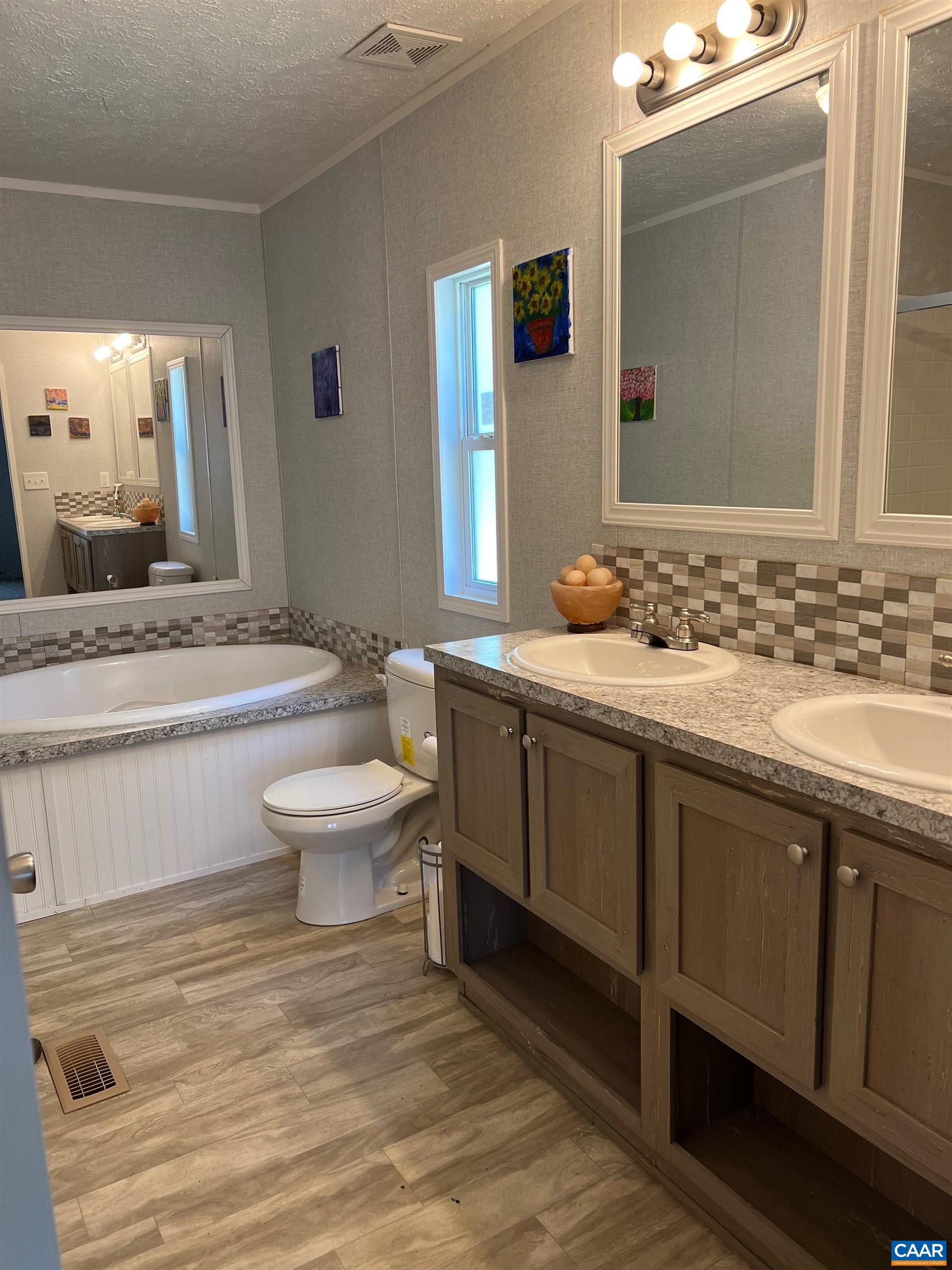 1261 Miles Jackson Road Palmyra, VA 22963 - Photo 24 of 40 a bathroom with a granite countertop toilet a sink and a mirror