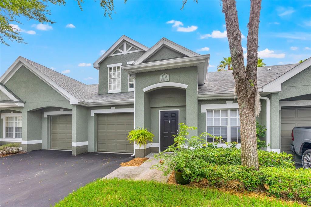 3633 Kings Road, Unit 102 Palm Harbor, FL 34685 - Photo 1 of 24 a front view of a house with a garden and yard