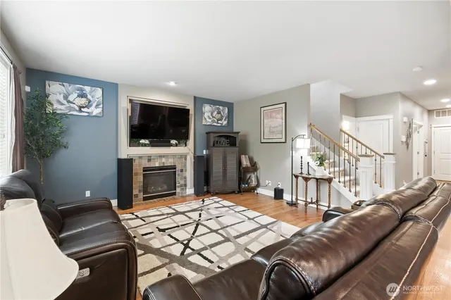a living room with furniture a flat screen tv and a fireplace