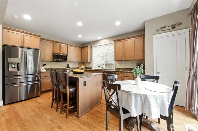 a kitchen with a table chairs refrigerator and microwave