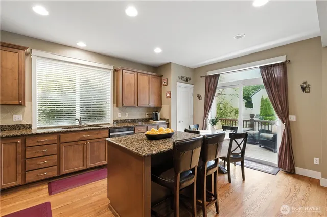 a kitchen with granite countertop sink stove dining table and chairs