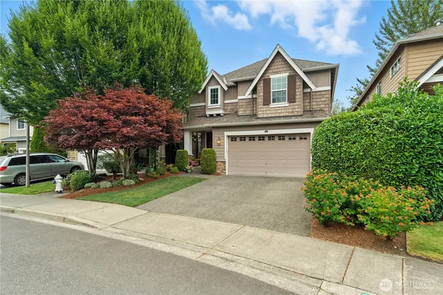 a view of front a house with a yard and garage