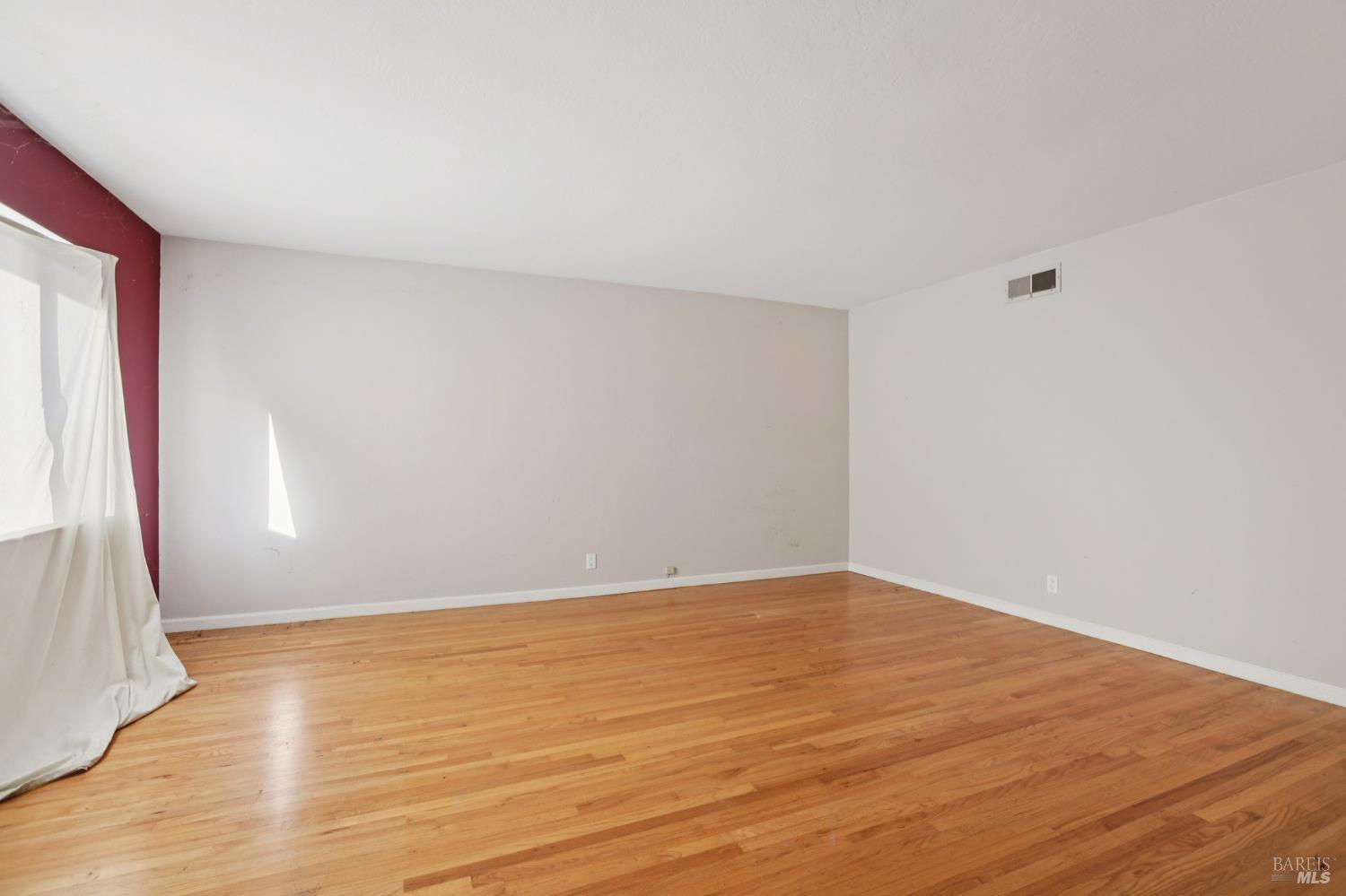 1023 Avondale Lane Hayward, CA 94545 - Photo 21 of 24 an empty room with wooden floor and window