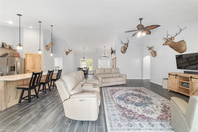 a large kitchen with stainless steel appliances kitchen island granite countertop a stove a sink dishwasher and a fireplace with wooden floor