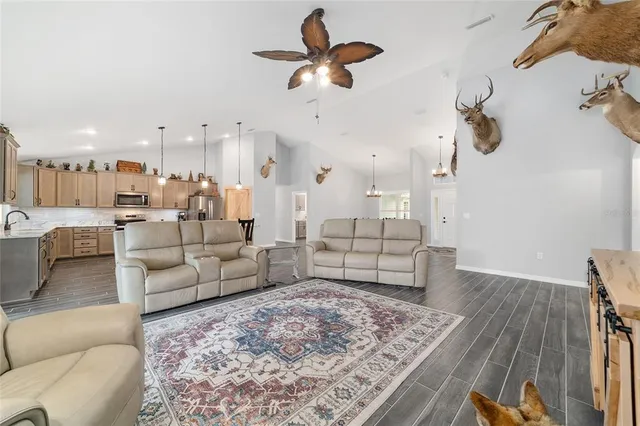 a open kitchen with stainless steel appliances granite countertop a refrigerator a sink dishwasher a stove and white countertops with wooden floor