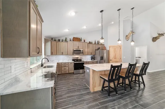 a view of a kitchen with sink and dishwasher with wooden floor