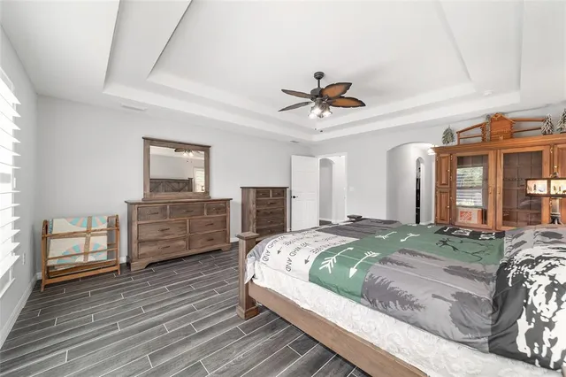 a view of a house with a big yard potted plants and a large tree