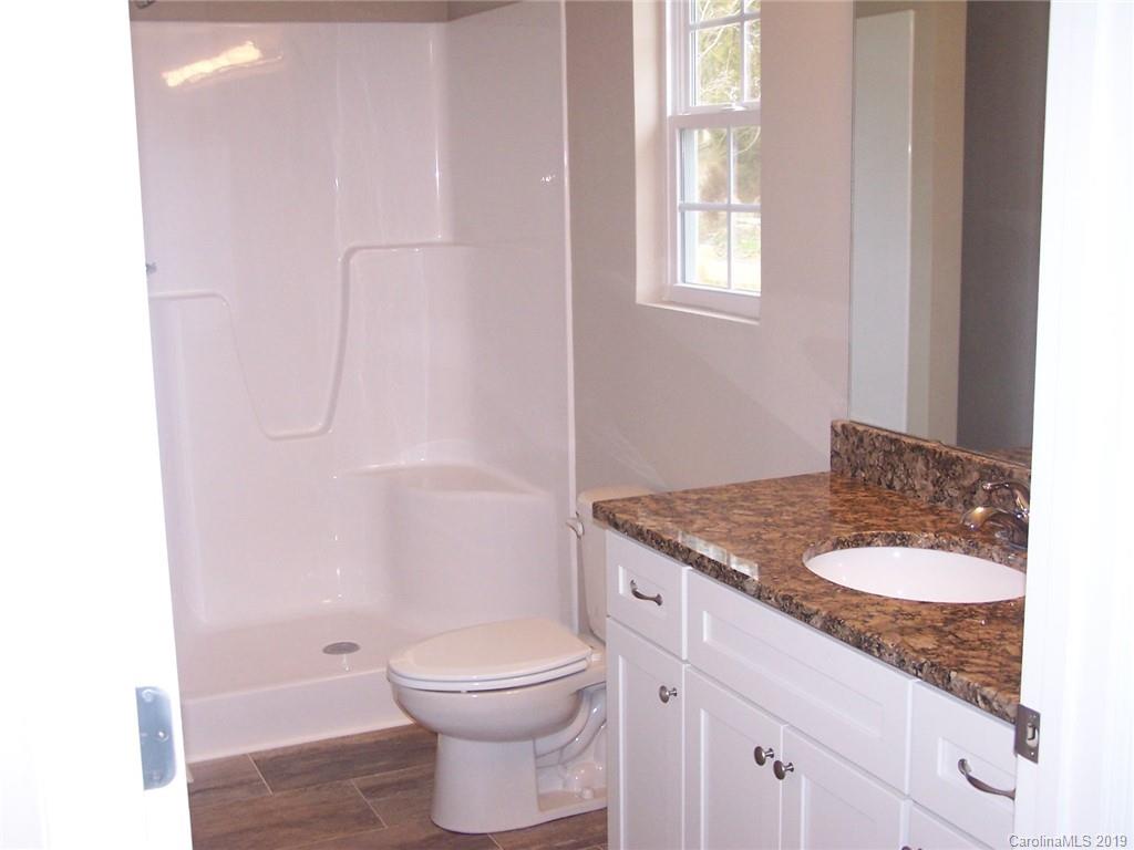 400 Rowan Mill Road Salisbury, NC 28147 - Photo 16 of 24 a bath room with a granite countertop toilet a sink and a mirror