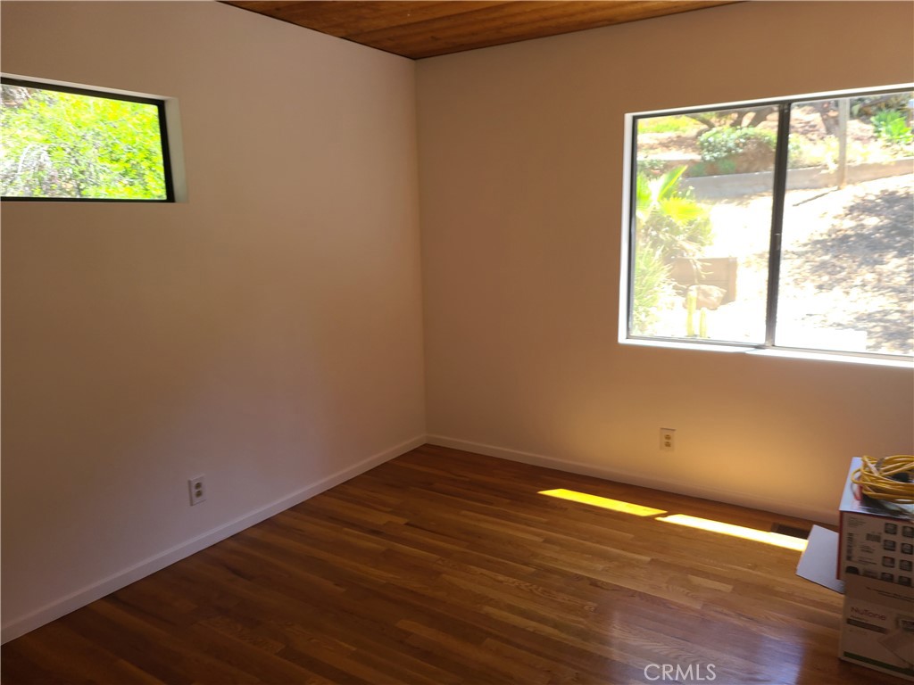 243 Amy Way Topanga, CA 90290 - Photo 11 of 31 an empty room with wooden floor and windows