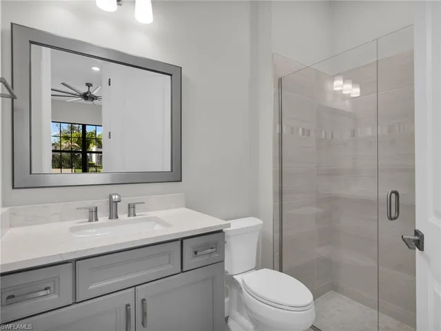 an empty room with windows and ceiling fan