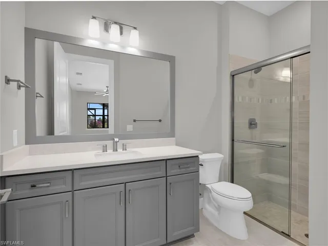 an empty room with windows and ceiling fan