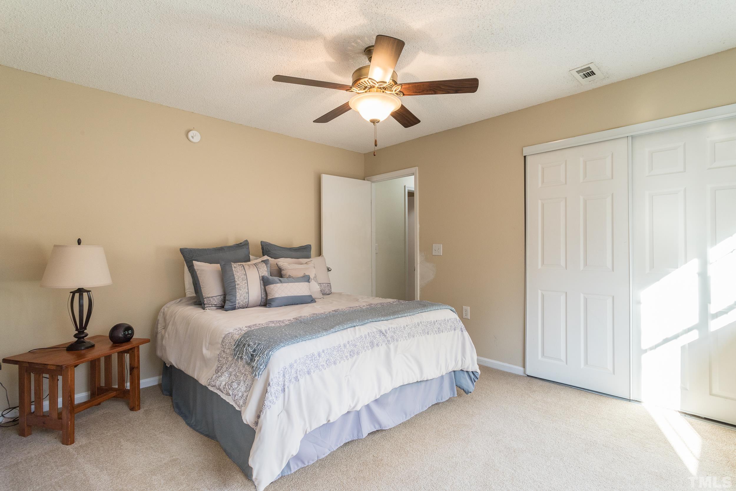 7808 Falcon Rest Circle Raleigh, NC 27615 - Photo 2 of 28 a bedroom with bed and a chandelier