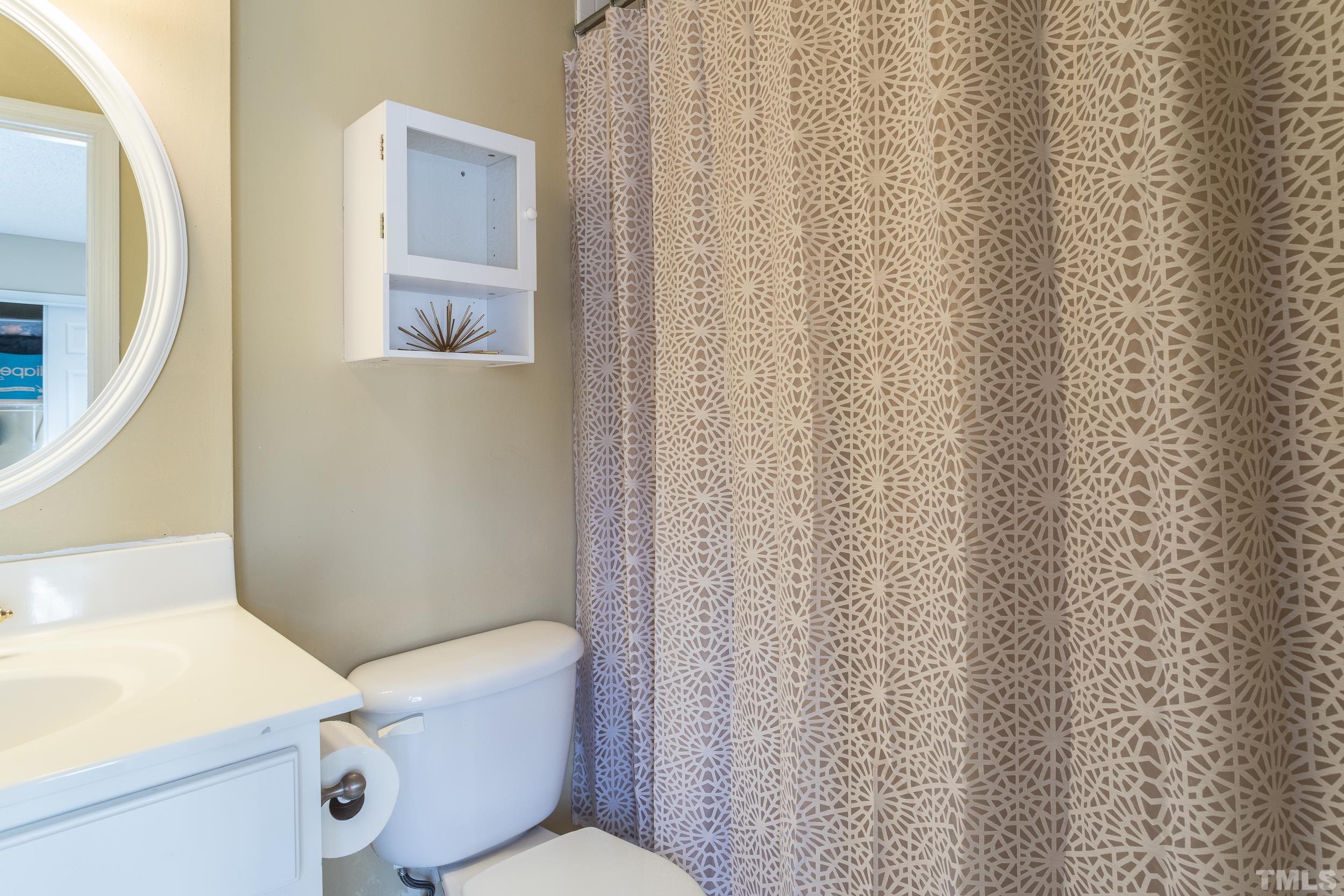 7808 Falcon Rest Circle Raleigh, NC 27615 - Photo 4 of 28 a white toilet sitting next to a shower curtain