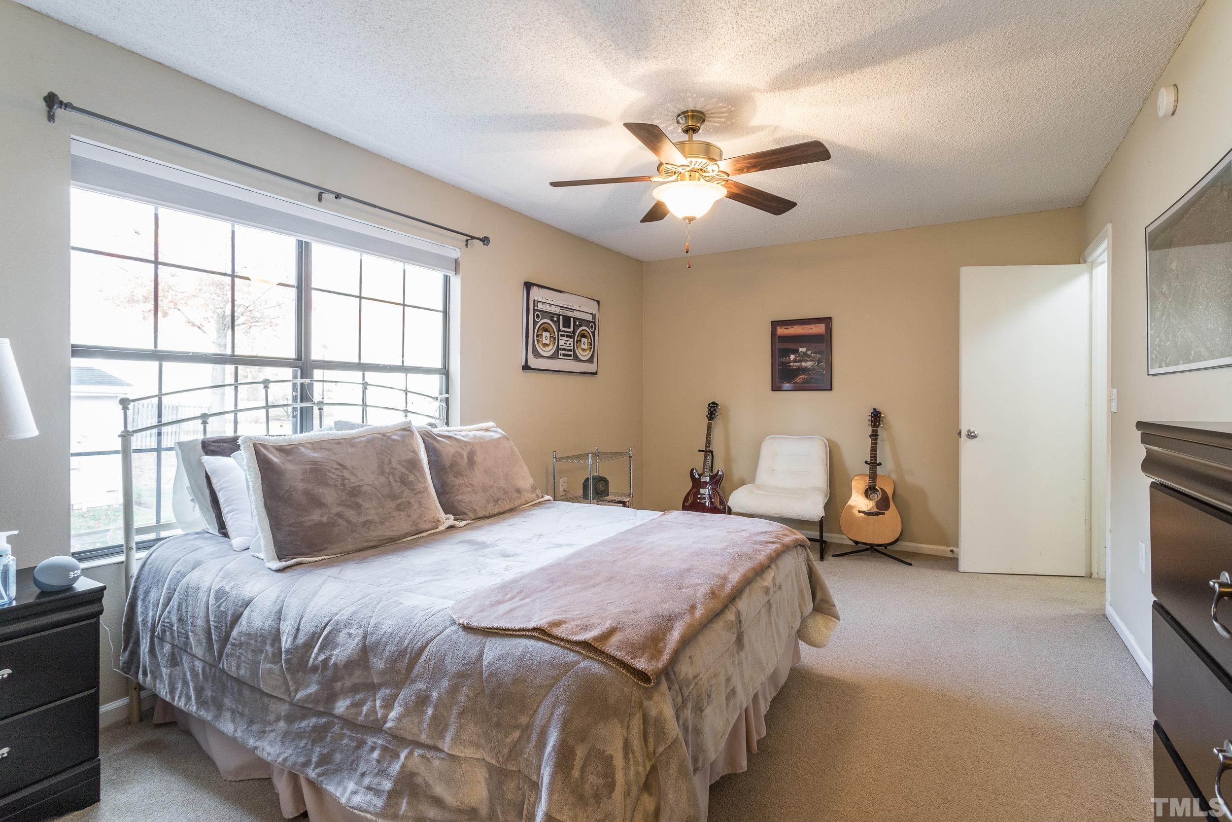 7808 Falcon Rest Circle Raleigh, NC 27615 - Photo 6 of 28 a bedroom with a bed and a chandelier