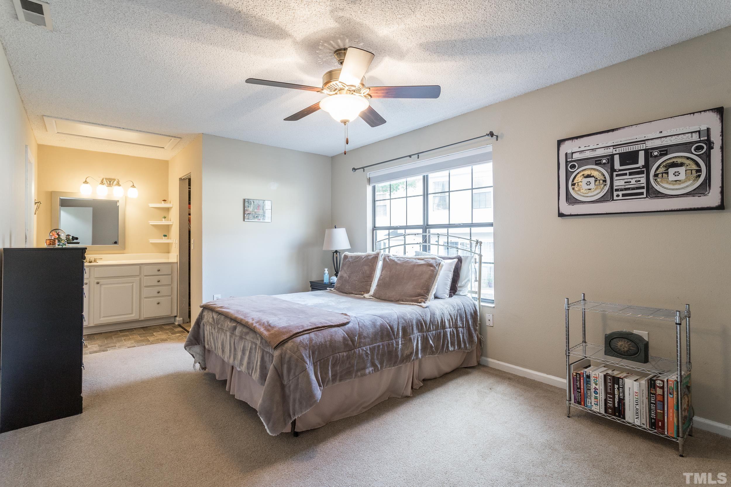7808 Falcon Rest Circle Raleigh, NC 27615 - Photo 9 of 28 a bedroom with a bed and a chandelier
