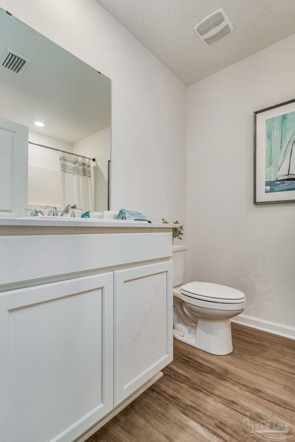 7757 Moonrise Way Milton, FL 32583 - Photo 23 of 27 a bathroom with a toilet a sink and mirror