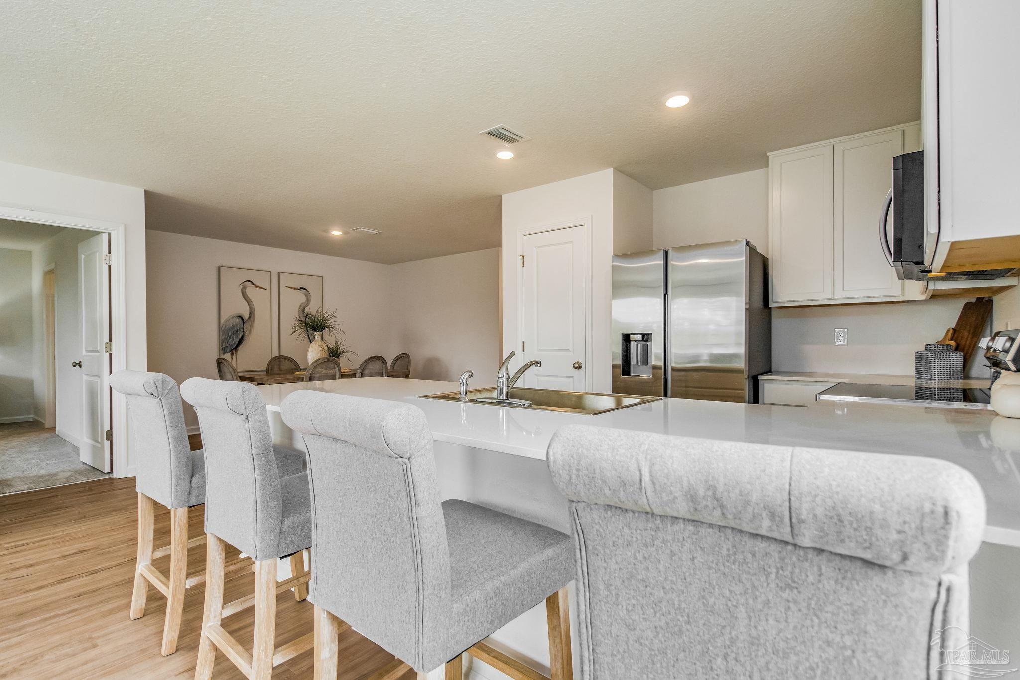 7757 Moonrise Way Milton, FL 32583 - Photo 3 of 27 a large kitchen with a table and chairs