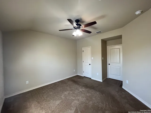 an empty room with a window and a fan