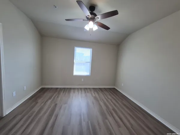 a view of an empty room and cabinet with a ceiling fan