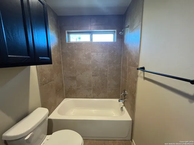 a bathroom with a granite countertop toilet sink and mirror