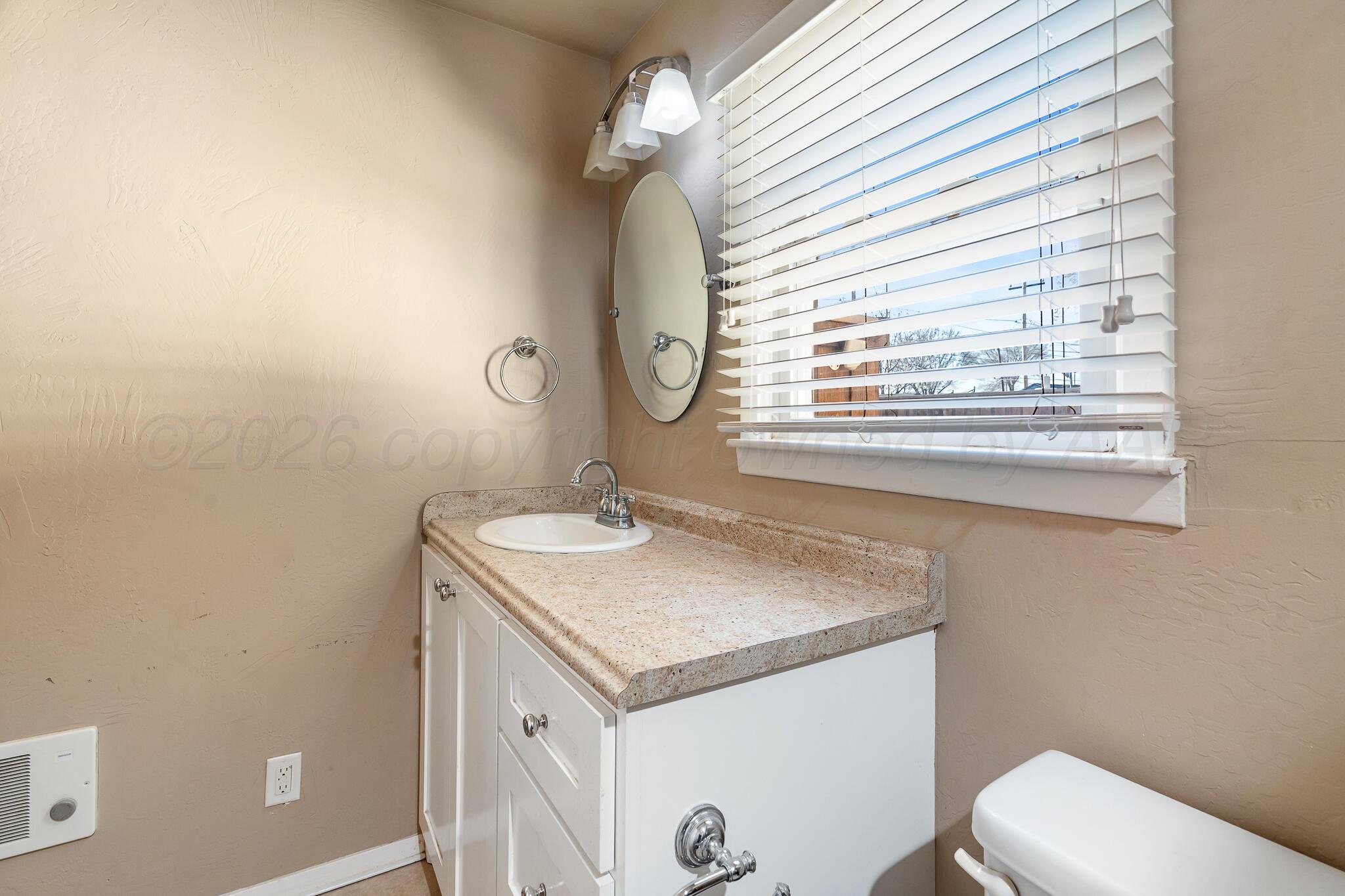 710 North Roberts Street Amarillo, TX 79107 - Photo 14 of 20 a bathroom with a granite countertop sink a toilet and a mirror
