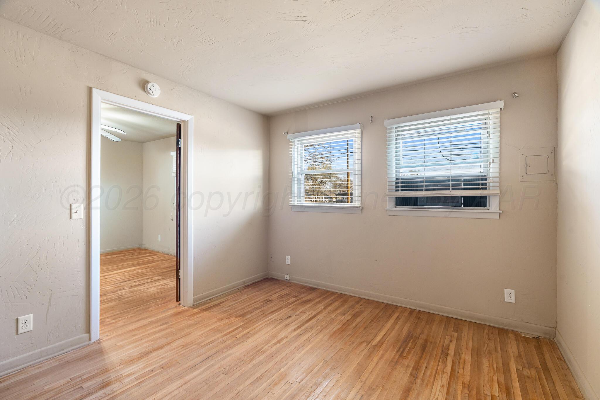 710 North Roberts Street Amarillo, TX 79107 - Photo 10 of 20 an empty room with wooden floor and windows