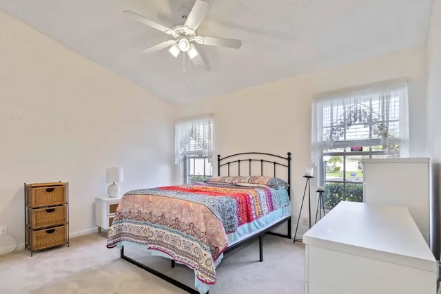 a bedroom with a bed a chandelier and a dresser