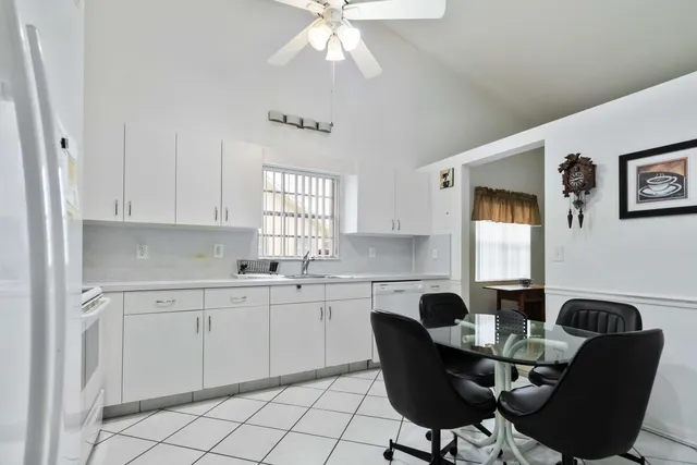 a kitchen with stainless steel appliances kitchen island granite countertop a stove a sink a refrigerator a dining table and chairs