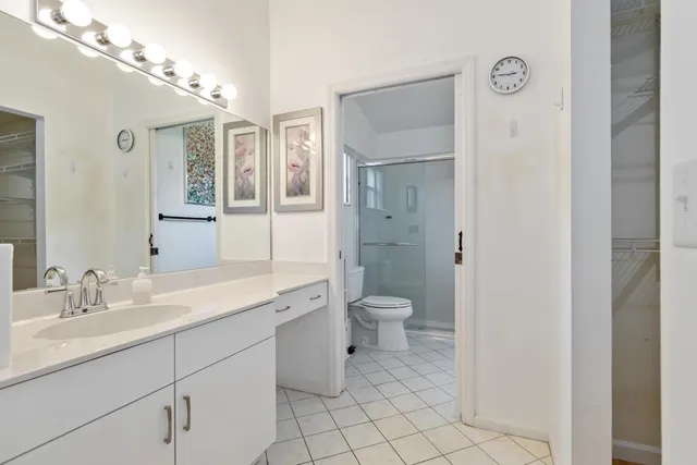 a spacious bathroom with a toilet a sink and mirror