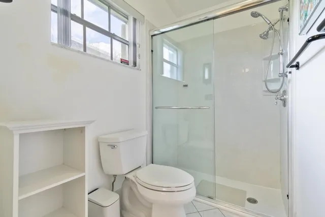 a white toilet sitting next to a bathroom shower