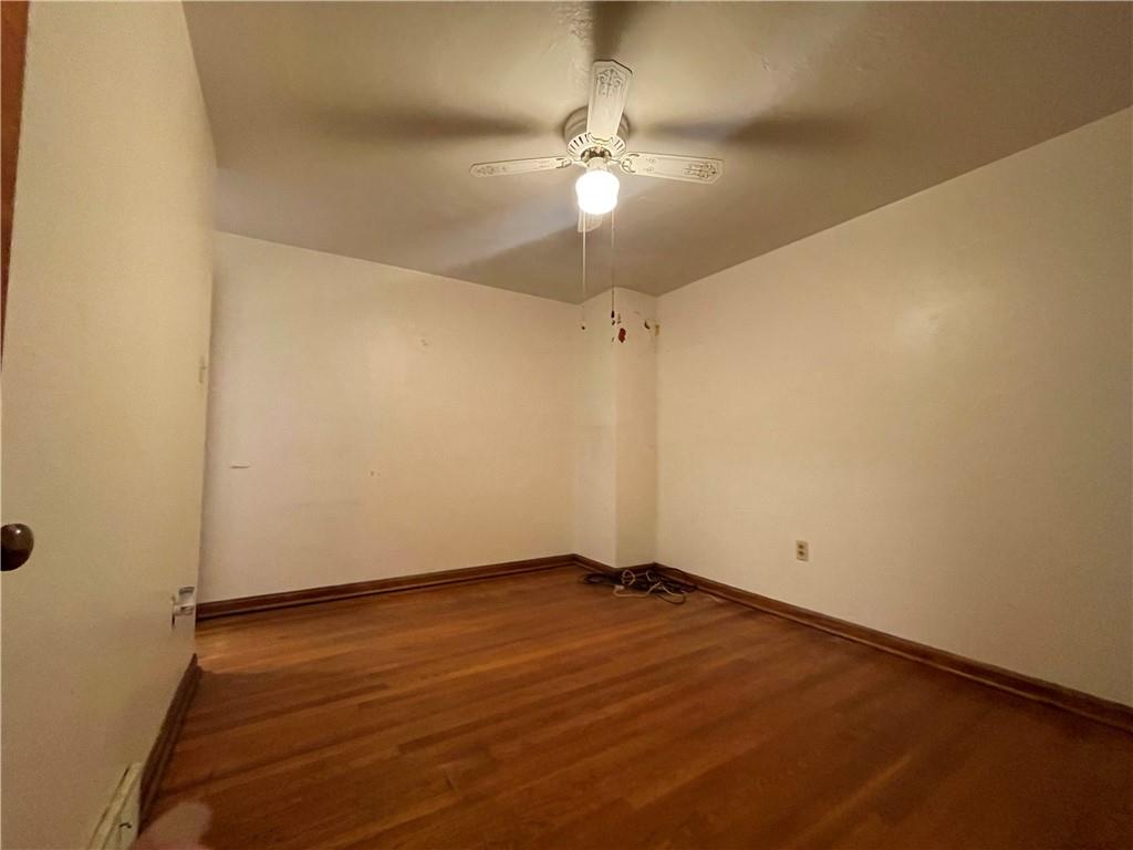 417 North 6th Avenue Butler, PA 16001 - Photo 16 of 25 an empty room with a ceiling fan and wooden floor