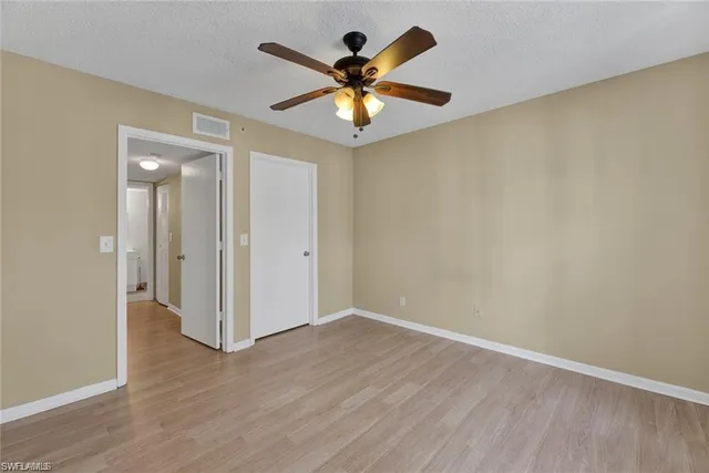 wooden floor in an empty room with a fan