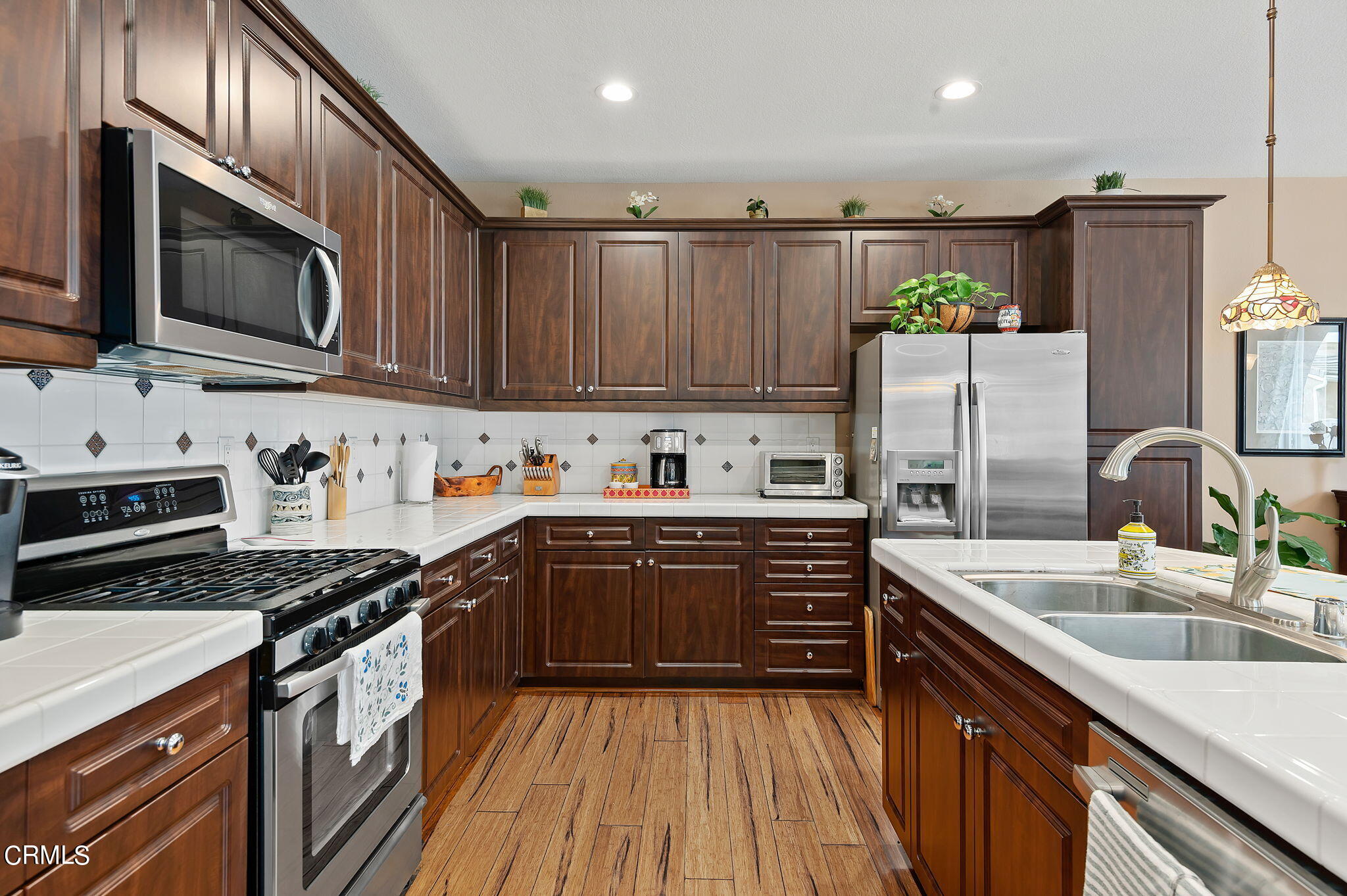 3630 Jolly Roger Way Oxnard, CA 93035 - Photo 10 of 24 a kitchen with stainless steel appliances granite countertop wooden cabinets stove top oven and sink